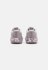 Baskets de sport violettes et blanches avec un dessus texturé, une semelle rembourrée et un intercalaire à motif avec un design camouflage.