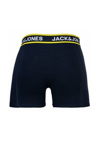 Boxer-briefs bleu foncé avec une ceinture jaune et blanche arborant le texte "JACK & JONES" en gras. Tissu lisse avec une coupe près du corps.