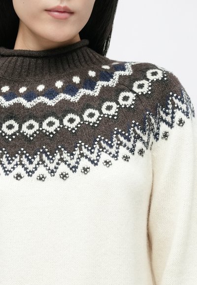 Striktrøje med høj krave, i brune og kremfarvede nuancer, geometriske mønstre og udsmykninger langs yoke-området.