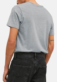 Grijze korte mouwen t-shirt van katoen, met een rechte snit en een ronde halslijn, gedragen met zwarte denim jeans.