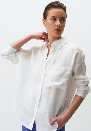 Witte linnen shirt met een casual pasvorm, knoopsluiting aan de voorkant en een enkele borstzak. Lange mouwen opgerold. Glad, lichtgewicht textuur.