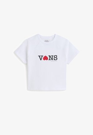 Camiseta corta blanca hecha de algodón. Presenta el logo negro de "VANS" con un ícono de corazón rojo en la parte frontal. Mangas cortas tipo raglán, escote sencillo.