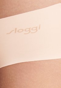 Intimo senza cuciture in tonalità nude con una sottile texture a coste. Presenta un discreto logo "sloggi" in stampa chiara sulla parte elastica.