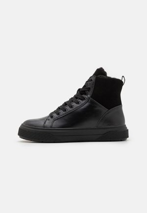Sorte høye sneakers med overdel i glatt lær, semsket lær aksenter, teksturert gummisåle og runde snørebånd. En løkkekrok er på hælen.