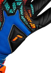 Torwart-Handschuh aus blauem Stoff mit schwarzen Latexakzenten, geometrischen Mustern in Türkis und Orange sowie einem auffälligen Logodetail.