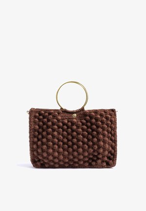 Bolso de mano de crochet marrón texturizado con asa circular de metal dorado y un pequeño cierre de botón dorado sobre fondo blanco.