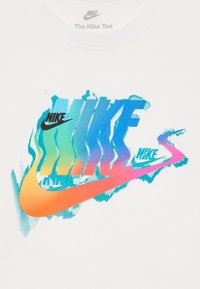 Camiseta blanca con un colorido diseño del logo de Nike en tonos degradados de azul, rosa y naranja, sobre un fondo texturizado.