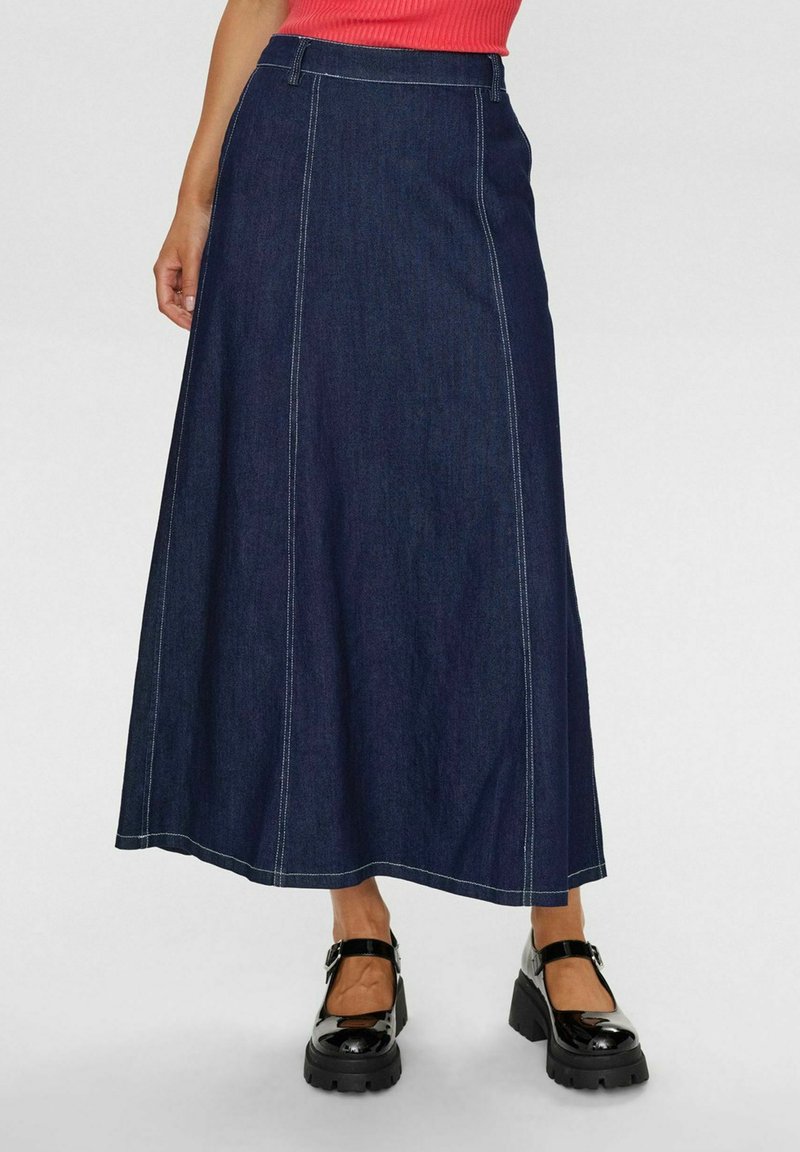 Tumši zili džinsa maksi svārki ar vertikālām šuvēm, taisnu griezumu un jostu. Savairoti ar melnām platformas kurpēm.