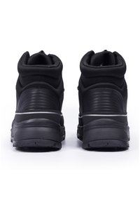 Svarta högskurna sneakers med en strukturerad tygöverdel, gummisula och en reflekterande rand runt mellansulan. Mjuk vadderad krage för komfort.