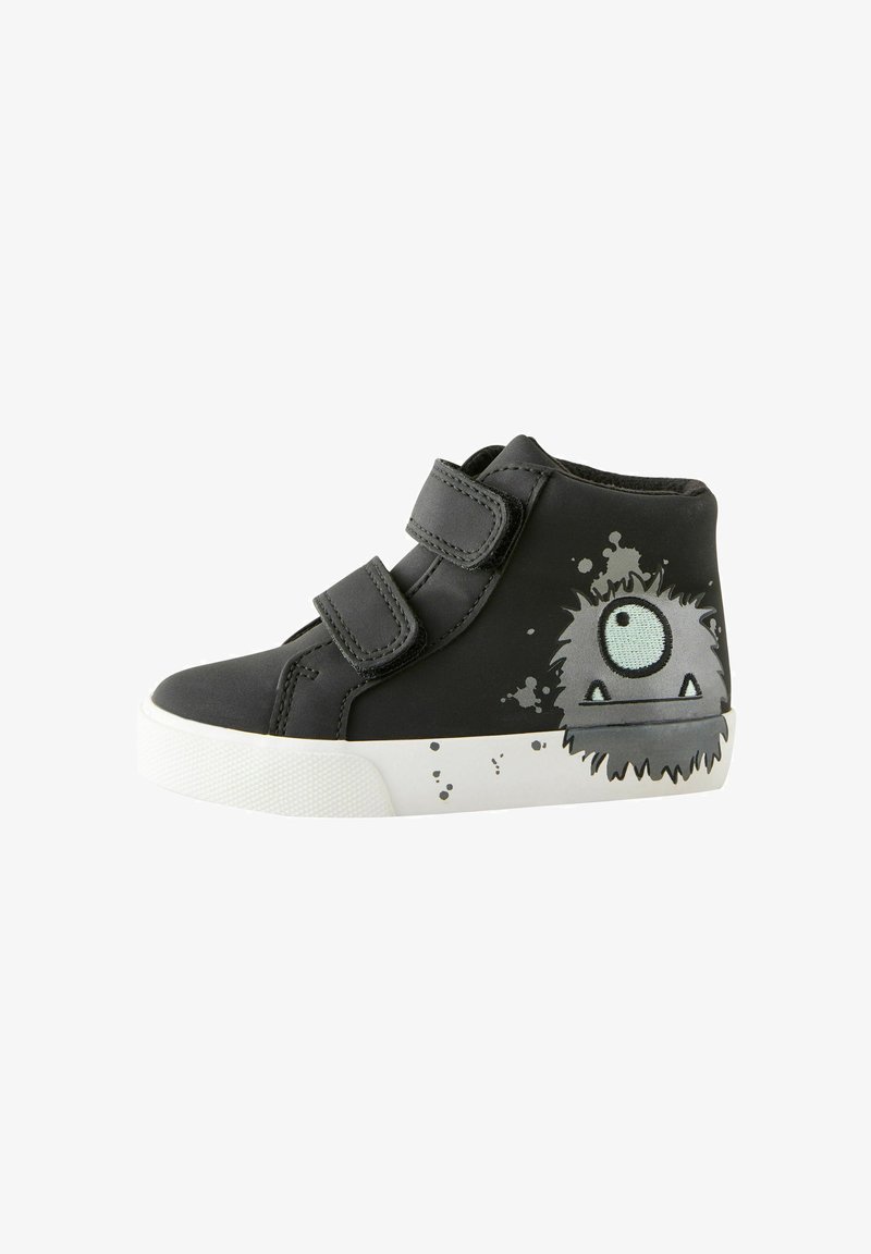 Scarpa alta nera con cinturini in Velcro, dotata di una suola in gomma bianca e un design grafico di un mostro grigio con un occhio singolo.