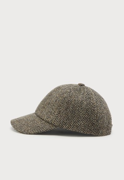 Casquette en laine marron et beige à motif chevrons avec une visière incurvée, vue de côté sur fond blanc.