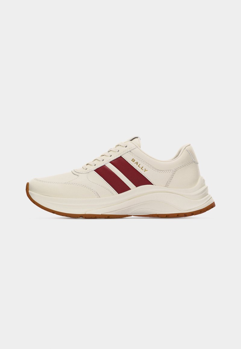 Baskets en cuir couleur crème avec deux bandes latérales rouges, logo "BALLY" doré, semelle blanche et bande de roulement marron, vues de profil gauche.