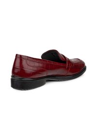 Mocassin en cuir rouge avec texture crocodile, semelle noire et talon bas, présenté de côté et légèrement en hauteur sur fond blanc.