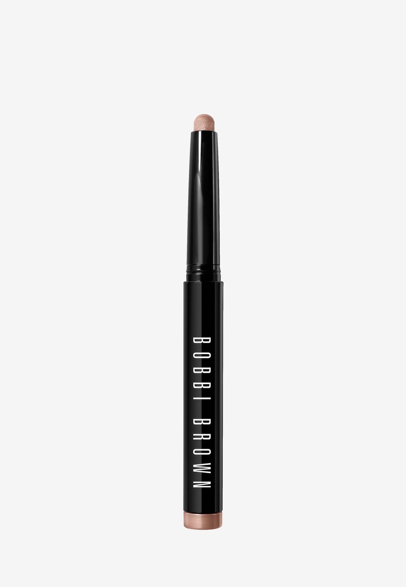 Bobbi Brown oogschaduwstick met een zwarte houder. Kenmerkt een afgeronde, lichtroze punt en een metallic bronzen basis. Soepele textuurontwerp.