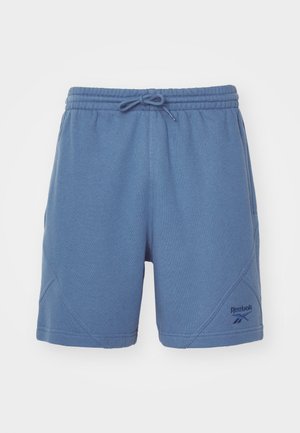 Modré športové šortky vyrobené z mäkkej tkaniny, s elastickým pásom a šnúrkou, šikmými švami a malým logom na dolnom leme.