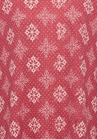 Rött tyg med ett vitt snöflingemönster och små prickar. Texturen ser mjuk ut med ett stickat eller vävt utseende.