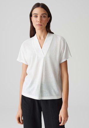 Witte top met korte mouwen en een V-halsontwerp, gemaakt van lichtgewicht, semi-doorzichtig materiaal. Eenvoudige, casual snit met een ontspannen pasvorm.