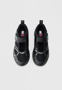 Μαύρα αθλητικά παπούτσια με δίχτυ, λουράκι βέλκρο και ανακλαστικές λεπτομέρειες. Διαθέτουν στρογγυλή μύτη και ανάγλυφη rubber σόλα.