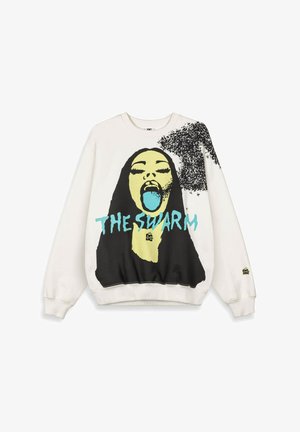 Sudadera blanca con un gráfico de una mujer de rostro amarillo con la boca abierta, lengua azul, cabello negro, un enjambre negro en el hombro y texto azul "EL ENJAMBRE."