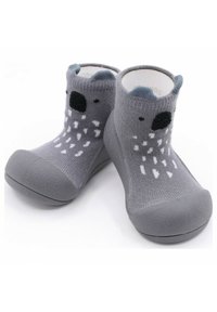 Calcetines infantiles grises con una suela de goma texturizada, que presentan una parte superior de punto con una cara de animal juguetona y un diseño estampado.