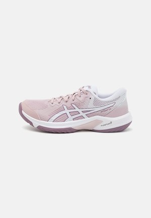 Scarpa sportiva rosa chiaro con parte superiore in mesh, dettagli bianchi e suola viola. Presenta una punta arrotondata, chiusura con lacci e strisce laterali a contrasto.