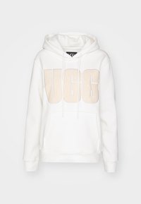 Biely mikina s veľkým béžovým logom UGG na prednej strane, s kapucňou na šnúrku, kengurským vreckom a rebrovanými manžetami a lemom.