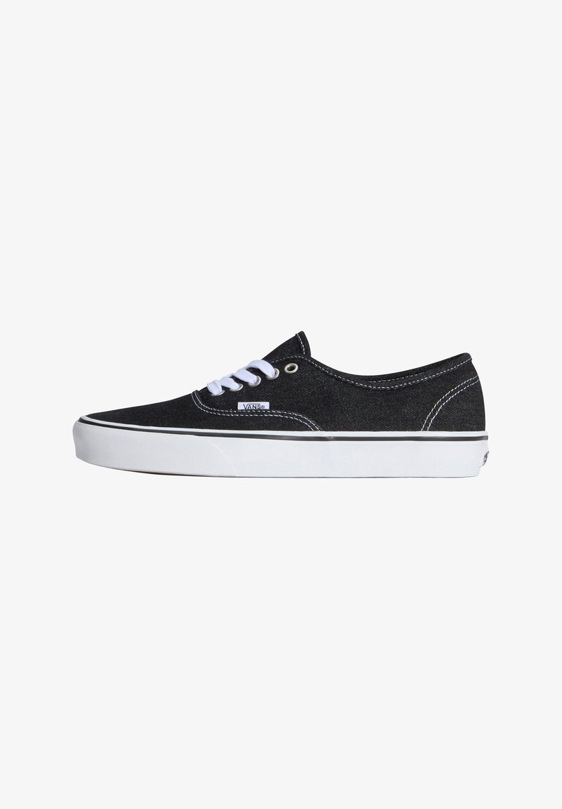 Μαύρο Vans sneaker χαμηλού τύπου με λευκή λαστιχένια σόλα, λευκά κορδόνια και ορατή ετικέτα της μάρκας στο πλάι, από την εξωτερική πλευρά.