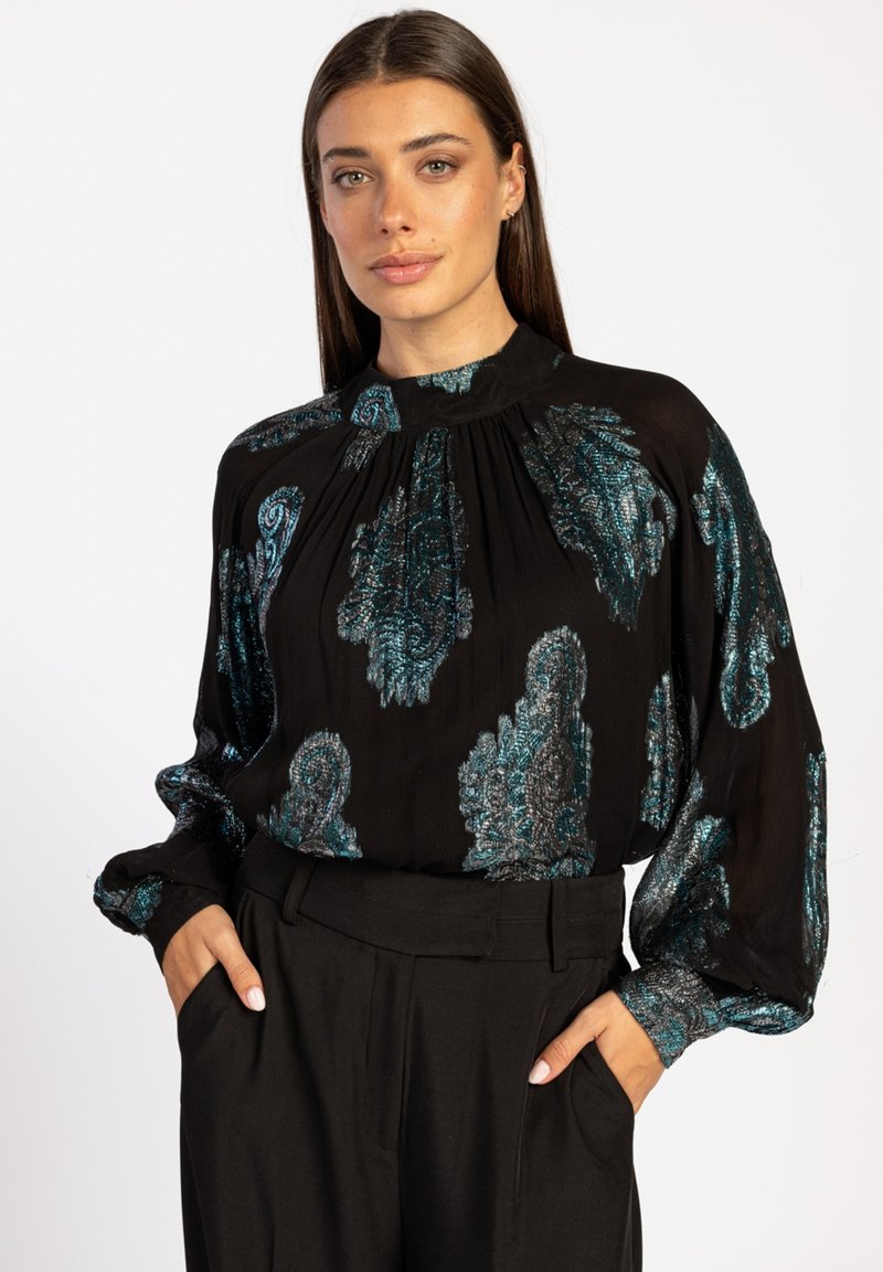 Zwarte blouse met lange mouwen en hoge nek, versierd met een metallic turquoise paisleypatroon, met plissé-details en een zachte textuur, gecombineerd met zwarte broeken.