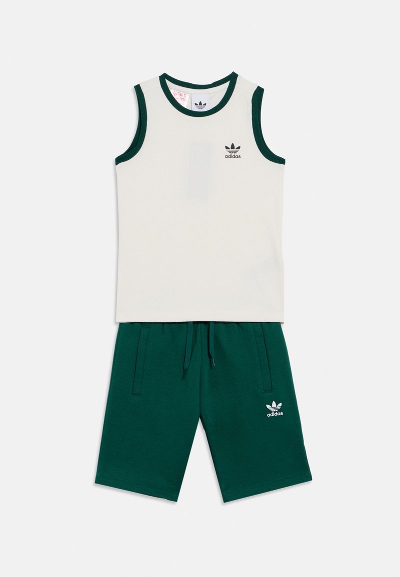 Ανοιχτό γκρι αμάνικη μπλούζα με πράσινες λεπτομέρειες και ταιριαστά πράσινα σορτς. Διαθέτει το λογότυπο της Adidas στο στήθος και στα σορτς. Ύφασμα με βαμβακερό μείγμα.