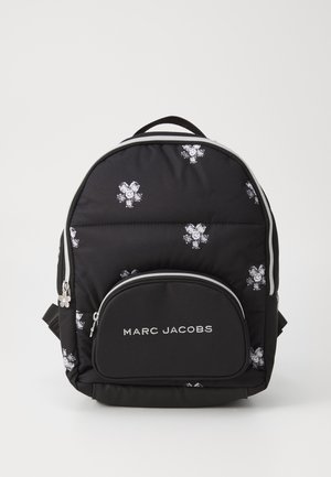 Mustassa tikatuissa reppu, jossa on hopeiset kukkakuviot, etupuolella vetoketjullinen tasku ja valkoisella kirjailtu "MARC JACOBS" -logo.