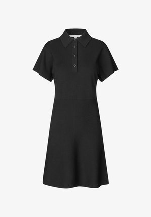 Melns polo kleita, izgatavota no adītas auduma, ar īsām piedurknēm, apkakles veidolu un pogājamu spraugu. Izplestā apakšdaļa nodrošina kuplumu.