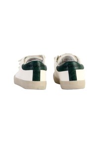 Weiße Sneakers mit grünen strukturierten Fersenelementen, runder Zehenpartie und hellgrauen Gummisohlen. Minimalistisches Design mit Schnürsenkeln.