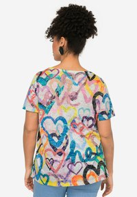 Korte mouw shirt van multicolor stof met een hartjespatroon en het woord "liefde." Ronde hals, ontspannen pasvorm, lichtgewicht textuur.