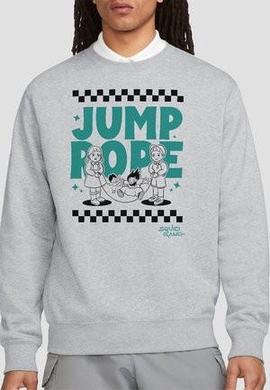 Gray sweatshirt features the text "JUMP ROPE" with illustrations of two children playing jump rope, and the words "SQUID GAME" in the corner.
