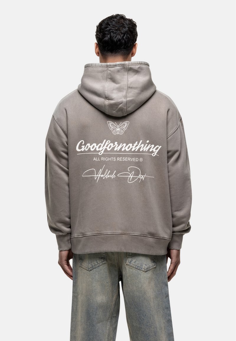 Sweatshirt à capuche gris avec un logo au dos. Présente un design de papillon et un texte en blanc disant "Goodfornothing". Fabriqué en tissu doux.