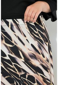 Sukně s vzorem v černé, zlaté a krémové barvě, s elastickým pasem a hladkou texturovanou látkou.