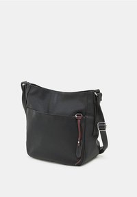 Musta nahkainen olkalaukku, jossa on teksturoitu pinta, säädettävä hihna ja vetoketju. Korostaa vastakkaista yksityiskohtaa. Monitoiminen muotoilu.