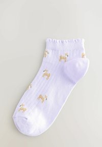 Lys lilla sok med ribbet tekstur, med små trykte gyldne hundedesign. Blød bomuldsblanding og bølget kantdetalje.