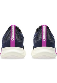 Baskets de running bleu foncé avec une tige texturée, une semelle intermédiaire blanche et des accents roses sur l'onglet du talon et le logo.