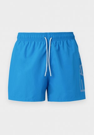 Blå badeshorts med elastisk midjebånd, hvit snor og subtilt geometrisk mønster på høyre side.