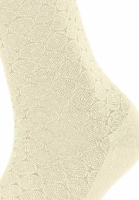 Beige Sock mit einem strukturierten Muster aus ineinandergreifenden Formen, hergestellt aus weichem Material mit einer glatten Oberfläche.