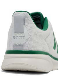 Białe siatkowe buty sportowe z zielonym akcentem na podeszwie, teksturowaną powierzchnią i uchwytem z tyłu z logo.