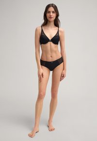 Black lingerie set featuring a padded bra with lace accents and matching high-waisted briefs, showcasing a smooth fabric and minimalistic design.