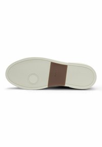 Black sneaker sole with a textured design, featuring a white rubber midsole and a brown leather accent with "BOSS" embossed.
