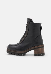 Zwarte leren enkelboot met een gestructureerde afwerking, hexagonale metalen ogen en een dikke bruine houten hak. Bevat een vachtvoering aan de bovenkant.