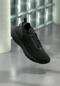 Μαύρα αθλητικά παπούτσια με διαπνέον άνω μέρος από πλεκτό υλικό, υφασμένο σχέδιο και εξωτερική σόλα από καουτσούκ, με κορδόνια και θηλιά στο πίσω μέρος.
