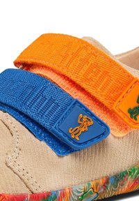 Geschlossene Schuhe mit einem Obermaterial aus beigem Wildleder, blauen und orangefarbenen Klettverschlüssen sowie einer mehrfarbigen, gemusterten Gummisohle mit einem Cartoon-Akzent.