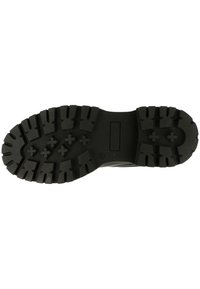 Suela de zapato de goma negra con profundos surcos y un diseño plano. Presenta patrones en zigzag y en bloques para mejorar la tracción. Material duradero.