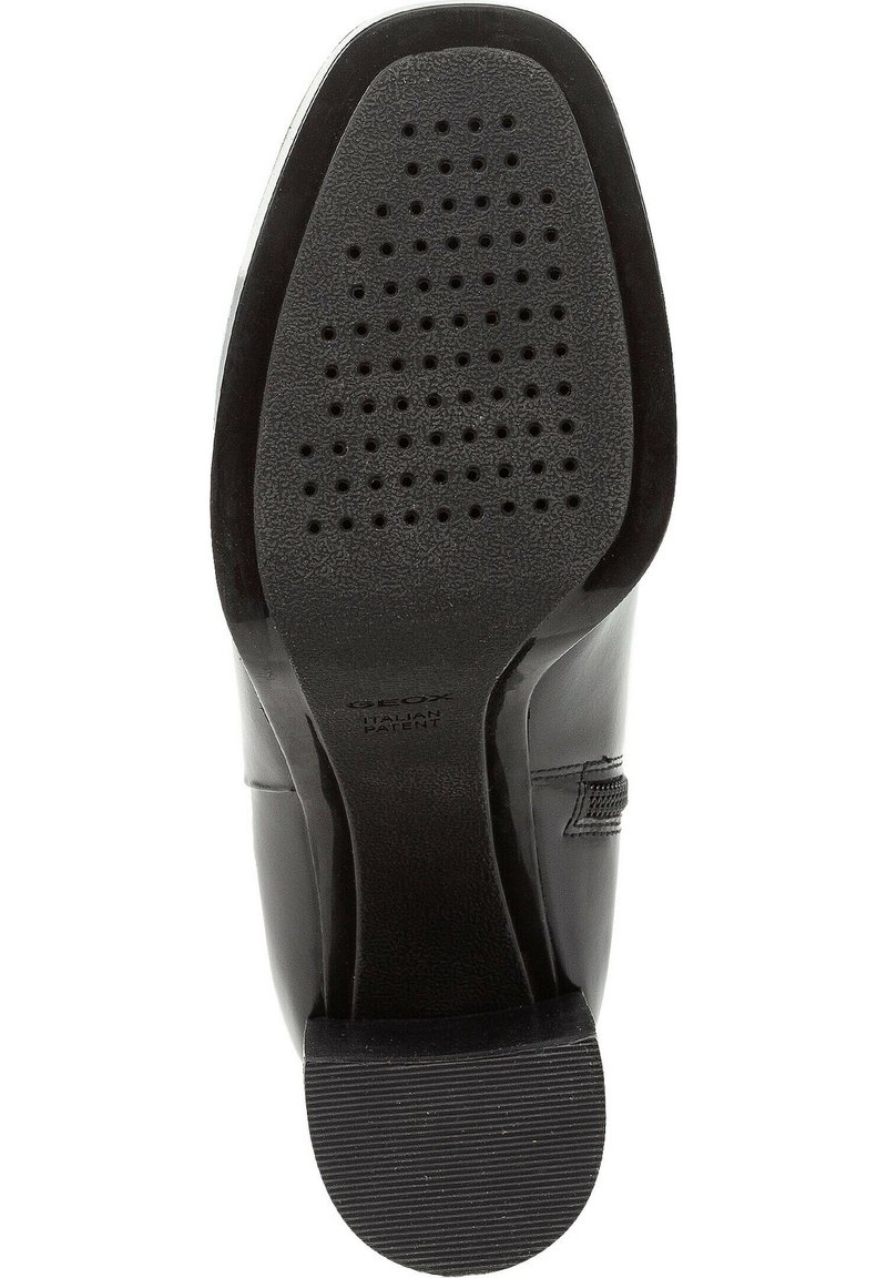 Semelle de chaussure en cuir noir avec une surface texturée, plusieurs trous de drainage et un accent de marque. Talon en caoutchouc robuste pour l'adhérence.