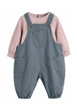 Salopete din denim gri cu două buzunare frontale și accente din butoane din lemn, asociate cu un top roz deschis cu mâneci lungi și manșete elastice.